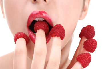 Sexy diet. Woman eating raspberries from fingers