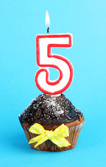 Poster - Birthday cupcake with chocolate frosting on blue background