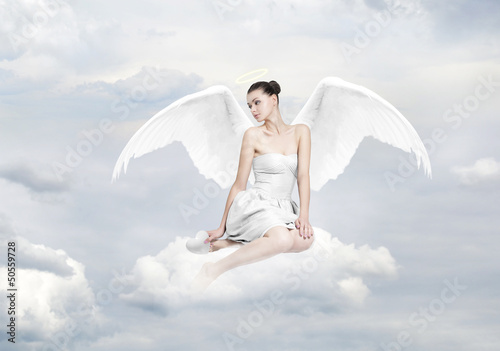 Naklejka ścienna Beautiful young woman as angel sitting on a cloud