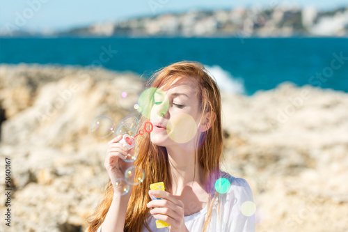 schöne frau pustet seifenblasen am meer Canvas Print