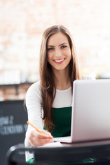 Poster - Young woman using laptop in cafe