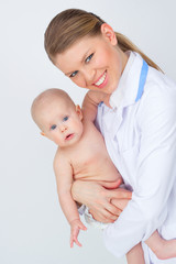 Wall Mural - Happy smiling pediatrician/ therapist woman holding lovely child