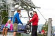 © CandyBox Images - Man helping couple holding bicycle chair lift