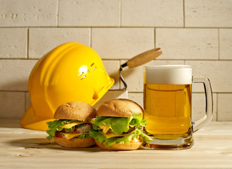 beer and burgers with the helmet against a brick wall