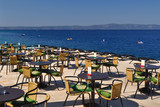Fototapeta Do akwarium - Tables and chairs of restaurant in beach of Podgora