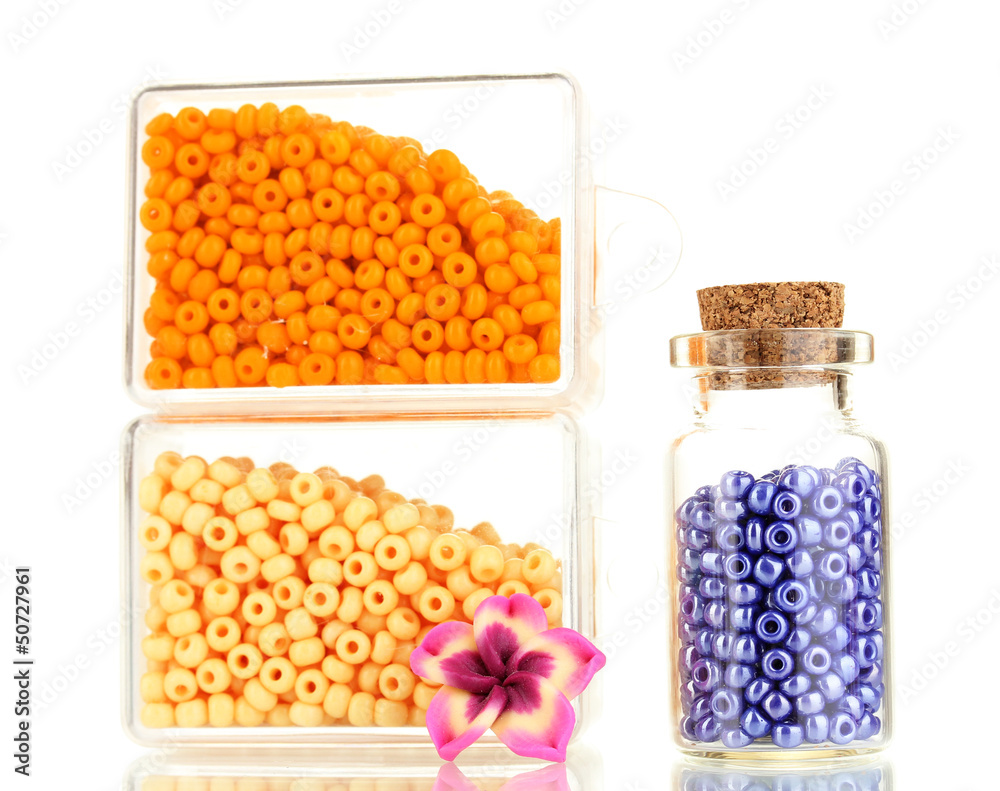 Colorful beads heap in boxes and glass bottle isolated on white