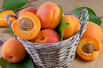 Wall Mural - fresh apricot in wicker basket on wooden background