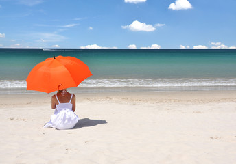 Wall Mural - Girl with an orange umbrella on the sandy beach