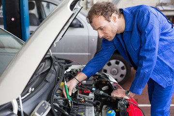 mechanic repairing a car in a workshop or garage