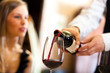 © Minerva Studio - Waiter pouring red wine to a woman