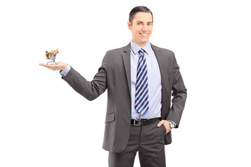 Sticker - Young professional man in a suit holding a small shopping cart w