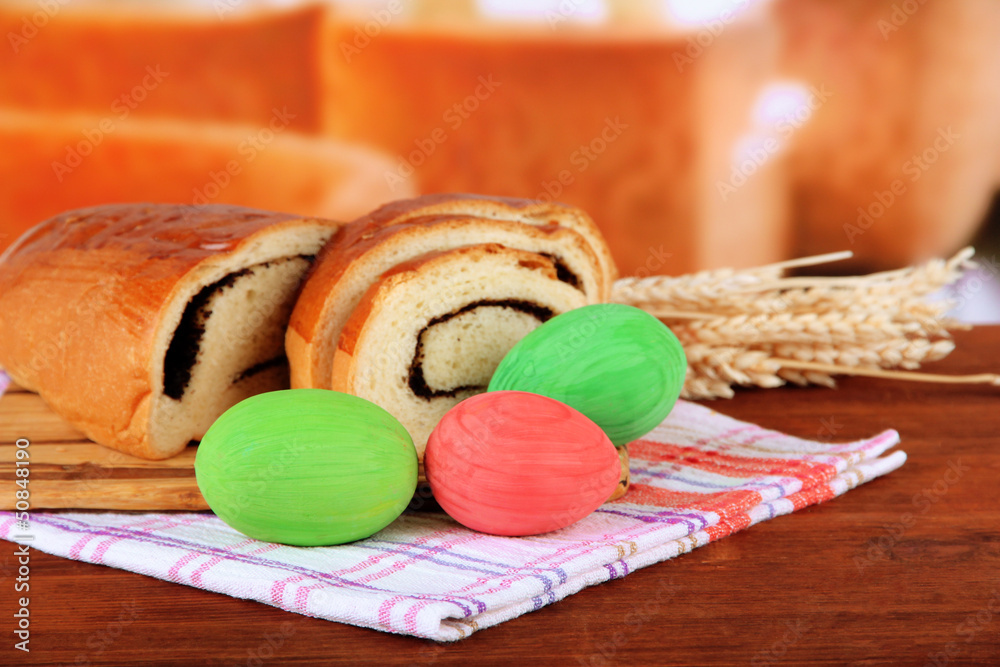 Loaf with poppy seed on cutting board, on bright background