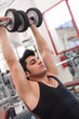 © pio3 - Young man exercising with dumbbells in a gym.