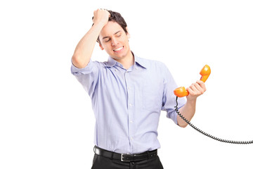 Wall Mural - Young man in trouble holding a telephone tube