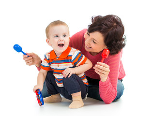 Mother and baby boy having fun with musical toys. Isolated on wh