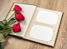 Photo Album And Roses On Wooden
