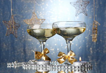 Two glasses of champagne on bright background with lights