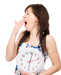 Young woman is holding big clock