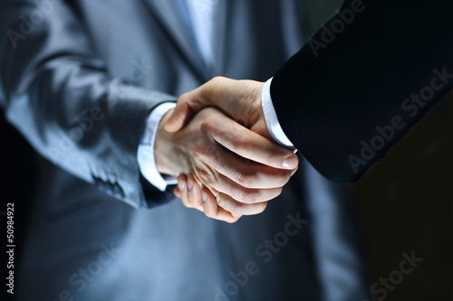 Fotografia Handshake - Hand holding on black background