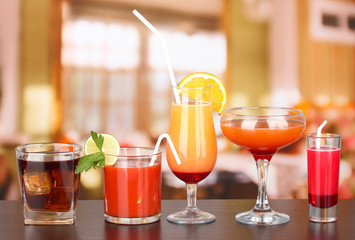 Wall Mural - Several glasses of different drinks on bright background