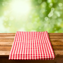 Wall Mural - Empty wooden table with tablecloth over bokeh background