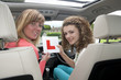 Female driver holding L learner plate with instructor