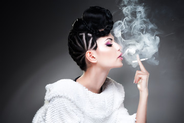 beautiful woman wearing make-up and hairstyle while smoking