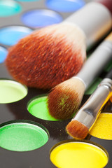 makeup brushes and palette of colorful eye shadows