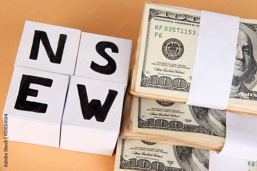 White paper cubes labeled "News" with money on beige background