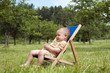 Baby or  toddler child relaxing in a garden.