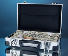 Wall Mural - Suitcase with 100 dollar bills on blue background