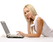© lenets_tan - Portrait of a woman lying on the floor and working on a laptop.