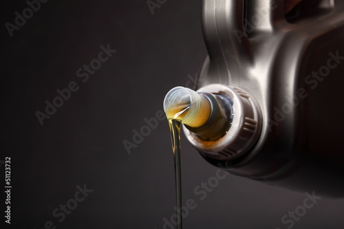 Cuadros en Lienzo Can with car engine oil pouring black background