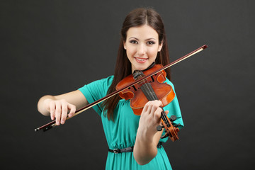 Wall Mural - Beautiful young girl with violin on grey background