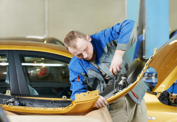 repairman grinding metal body car