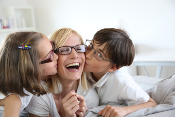 Portrait of children kissing her mom