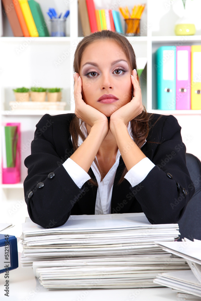 Sad business woman with documents in her workplace