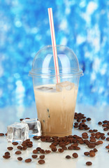 Poster - Cold coffee with ice in glass on blue background