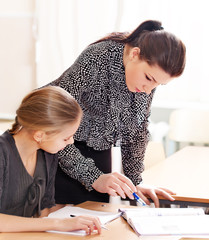 Portrait of a teacher explaining something to a smiling schoolbo