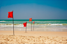 Swimming Is Dangerous In Ocean Waves. Red Warning Flag Flapping