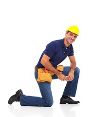 Wall Mural - handyman kneeling over white background