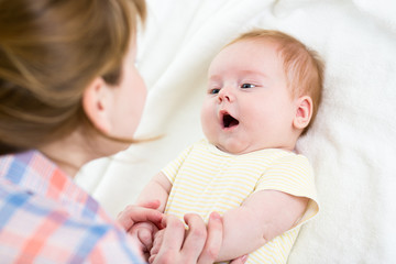 mother playing with baby boy indoors