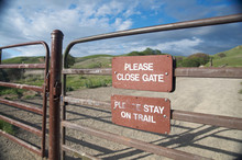 Sign Reminds Visitors To Stay On The Trail And To Close The Gate
