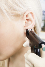 Girl Pierced Ear With A Special Equipment.