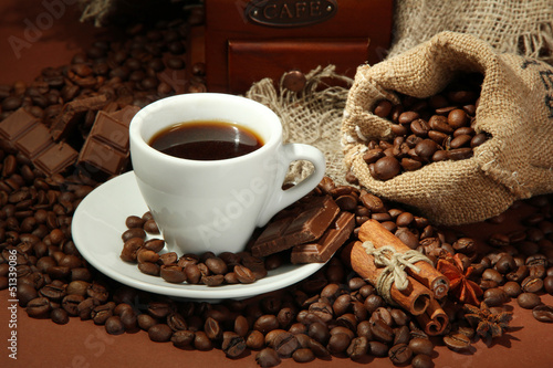 cup of coffee and coffee beans on brown background - 51339086