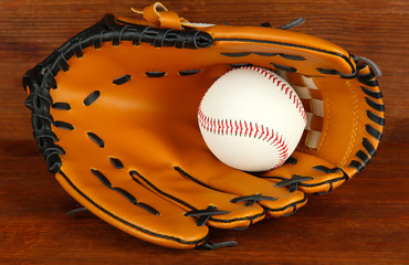 Wall Mural - Baseball glove and ball on wooden background