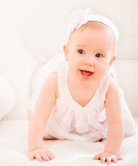 Wall Mural - little cute girl in a white dress and with flower smiling