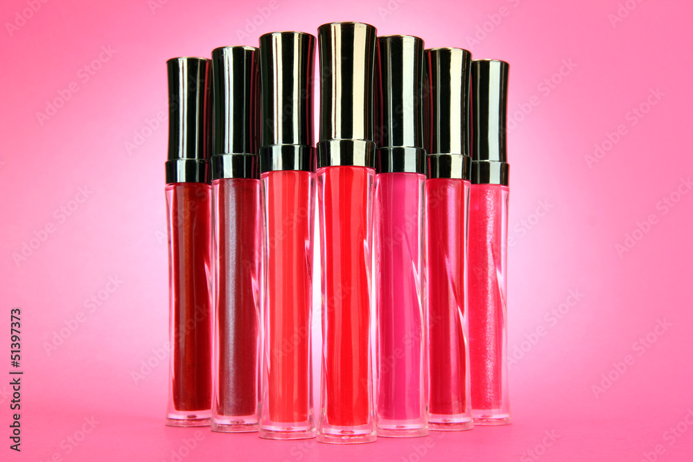 beautiful lip glosses, on pink background