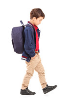 Full Length Portrait Of A Sad School Boy Walking