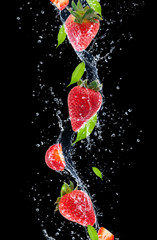 Strawberries in water splash, isolated on black background